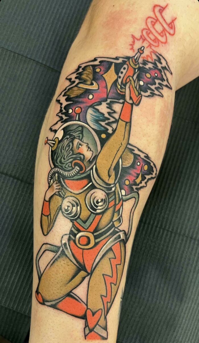 Space tattoo featuring a retro astronaut with a ray gun and cosmic background in vibrant colors.