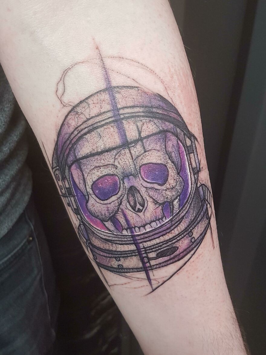 Skull inside an astronaut helmet tattoo, showcasing outer space cool design on forearm.