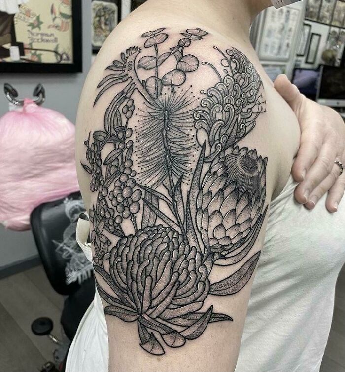 Elegant flower tattoo on shoulder, showcasing intricate botanical details that radiate beauty.
