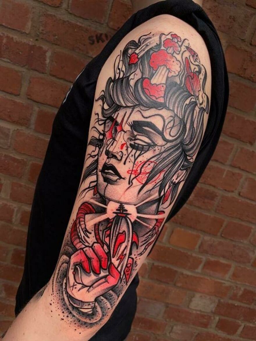 Arm tattoo of a celestial figure with red accents and cosmic elements, showcasing outer space cool design.