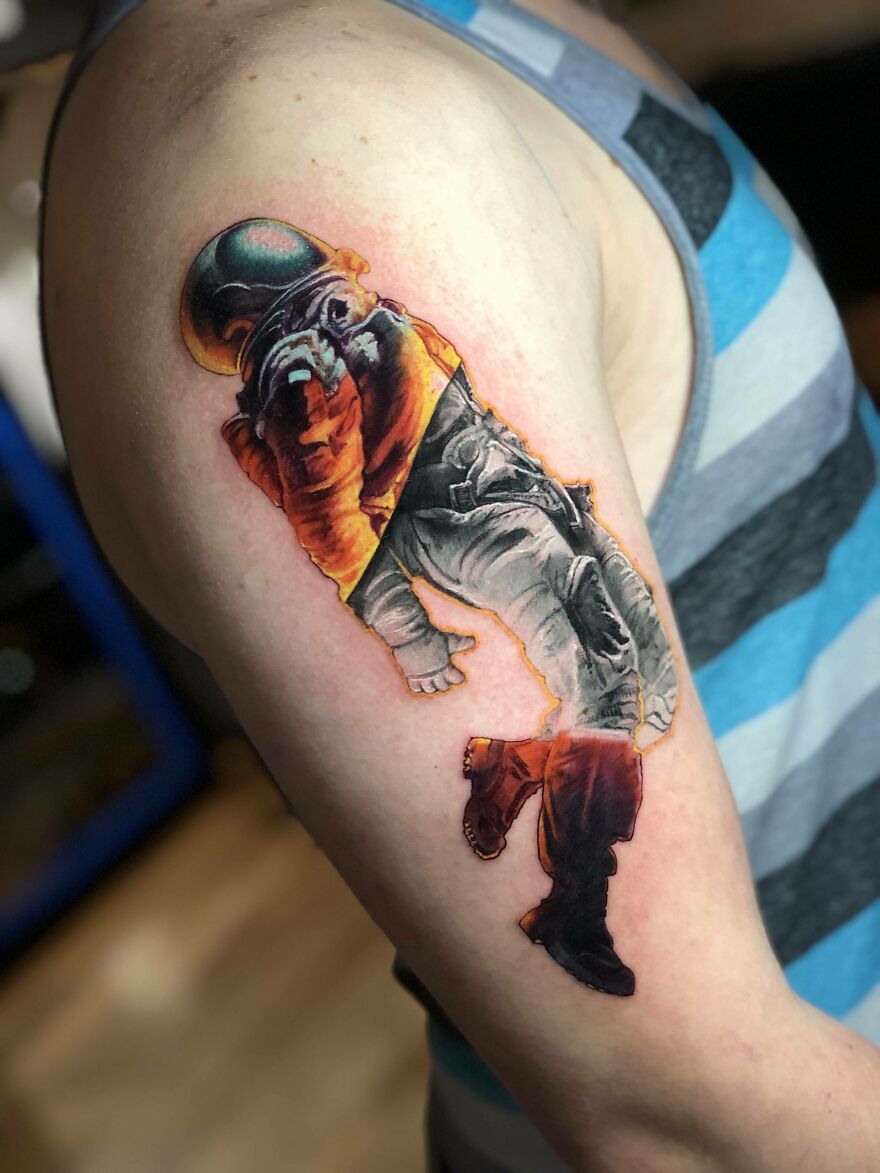 Tattoo of a space astronaut on a person's arm, featuring vibrant colors and detailed design.
