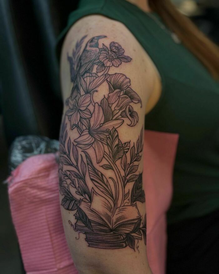 Floral tattoo design featuring lilies and leaves on a person's arm, showcasing elegance and beauty.