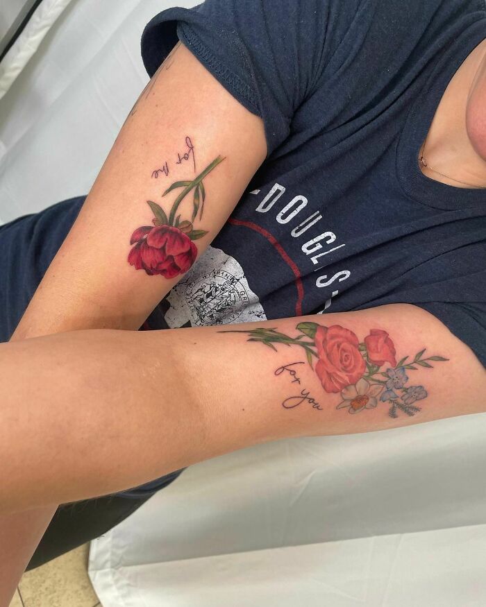 Floral tattoos on both arms with vibrant blooms and script, enhancing the skin's natural aesthetics.