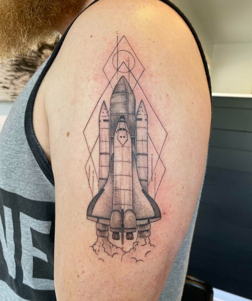 Space tattoo of a shuttle launching on an arm, showcasing outer space cool design.