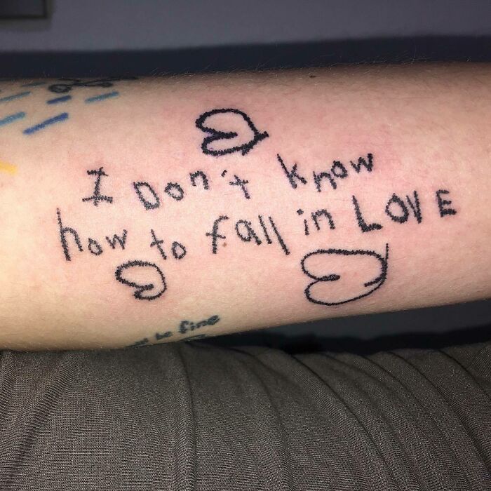 Self-love tattoo on arm with handwritten message and heart symbols.