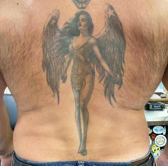 Back tattoo of an angel on aged skin, showing changes over time.