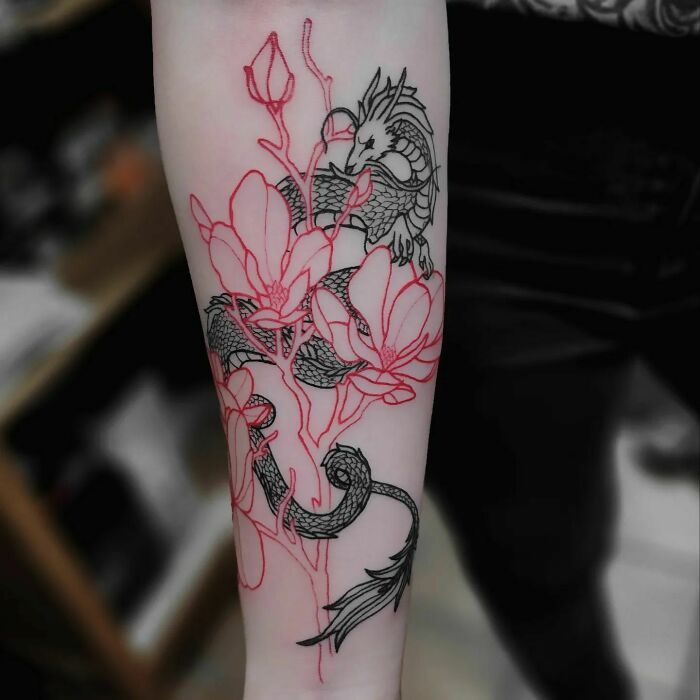 Dragon and flower tattoo on forearm with intricate design, showcasing art that seems to blossom on the skin.