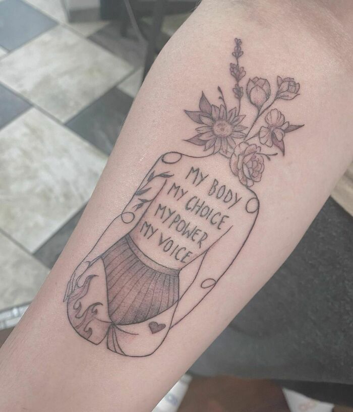 Self-love tattoo of a woman with flowers, featuring the message "My Body, My Choice, My Power, My Voice".