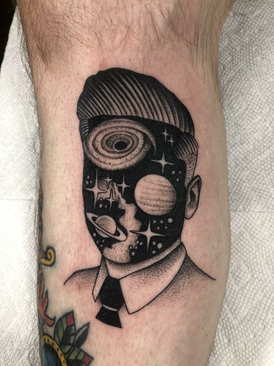 Space tattoo depicting a human face filled with planets, stars, and galaxies in a unique design.