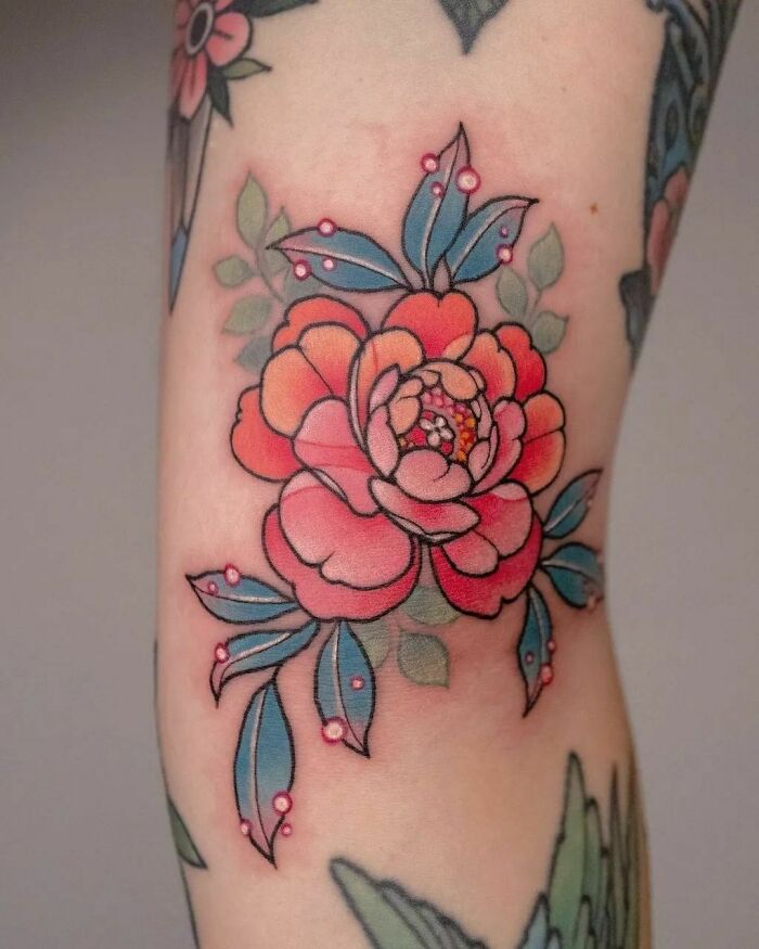Elegant flower tattoo with vibrant colors on arm, showcasing beauty and intricate design.