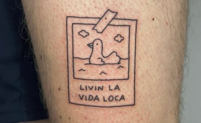 Duck tattoo with "Livin La Vida Loca" phrase, reflecting self-love celebration.