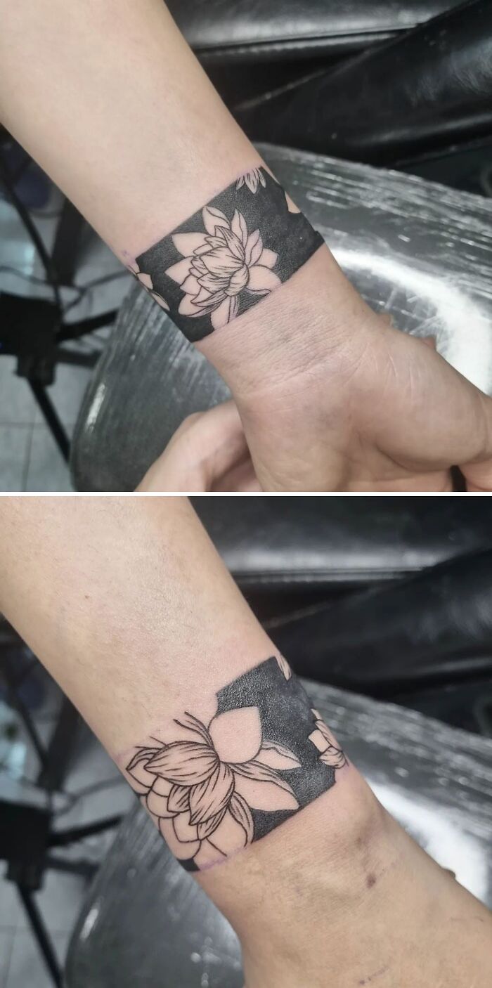 Flower tattoo on wrist blending intricate petal designs with dark background, creating a blooming effect on the skin.