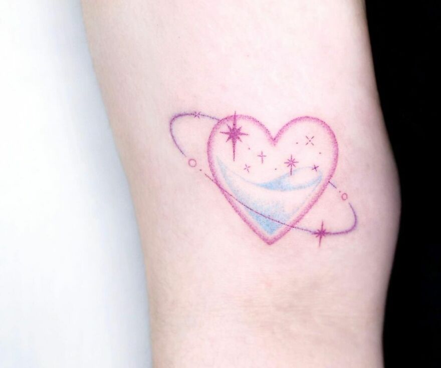 Heart-shaped space tattoo with stars and rings for astrology fans.