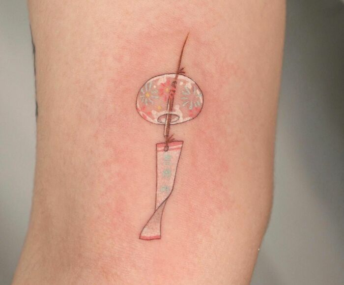 Delicate self-love tattoo with floral details on the forearm, featuring an artistic and subtle design.