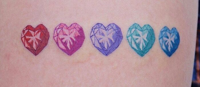 Colorful heart-shaped self-love tattoo with intricate geometric design on skin.