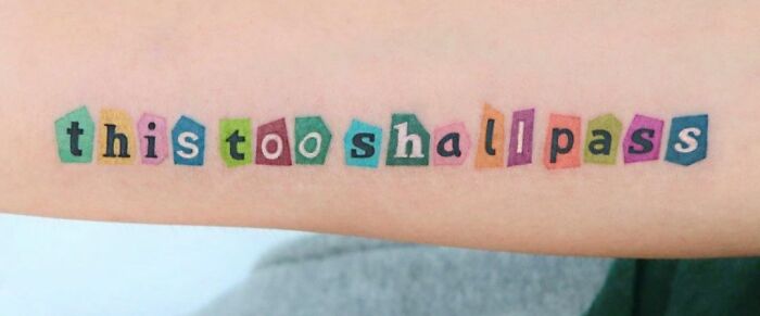 Colorful "this too shall pass" self-love tattoo on forearm.