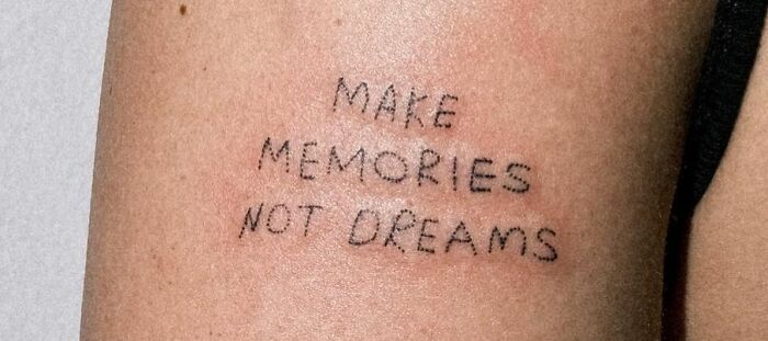 Tattoo on arm reading "Make Memories Not Dreams" representing self-love and empowerment.