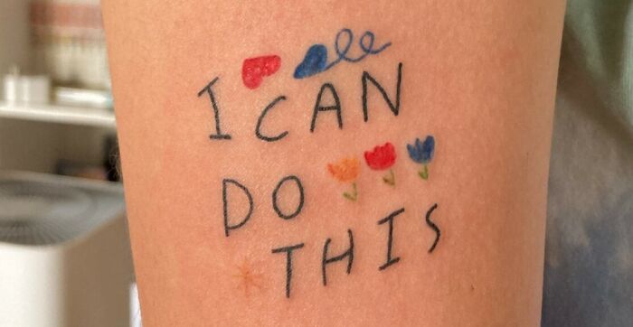 Self-love tattoo with the phrase "I can do this" and colorful flower designs, inspiring empowerment and positivity.