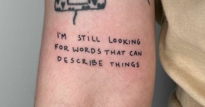 Self-love tattoo with the phrase "I'm Still Looking For Words That Can Describe Things" on an arm.