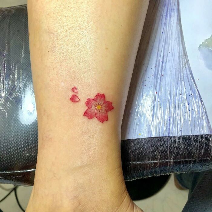 A delicate flower tattoo on a wrist, showcasing elegance and beauty.
