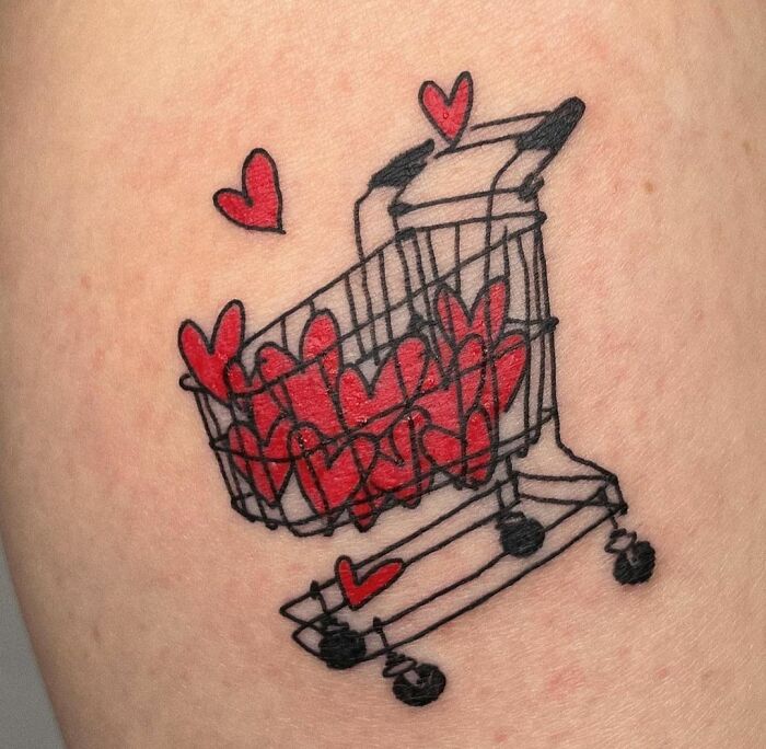 Shopping cart tattoo with red hearts symbolizing self-love and empowerment.
