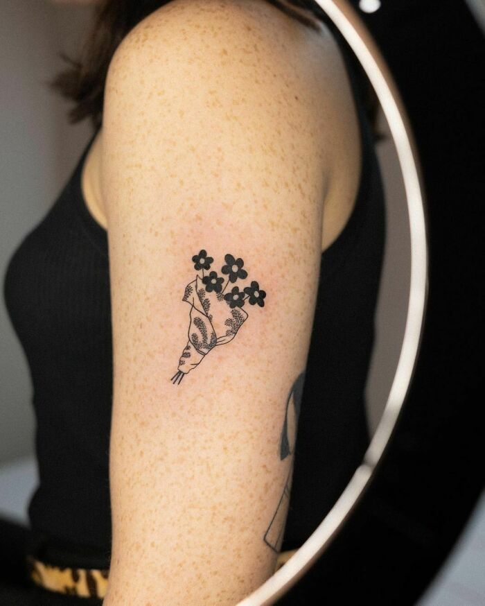 Floral tattoo design with black ink blossoms on an arm.