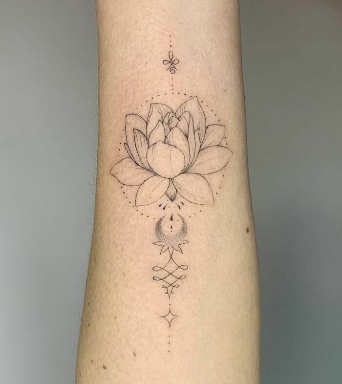 Elegant flower tattoo featuring a lotus design on forearm, showcasing beauty and intricacy.