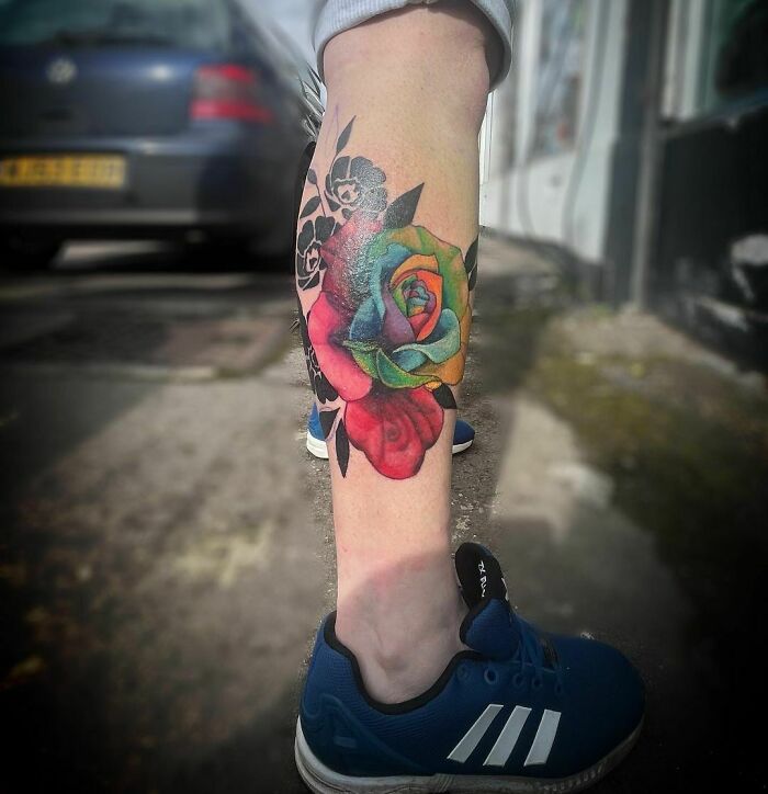Colorful flower tattoo on a leg, showcasing elegance and beauty.