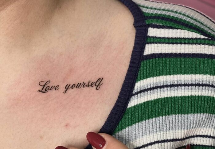 "Self-love tattoo with 'Love yourself' inked on the collarbone, symbolizing empowerment and inspiration."