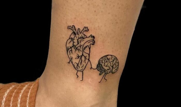 Heart and brain self-love tattoo on ankle symbolizes balance and inner strength.