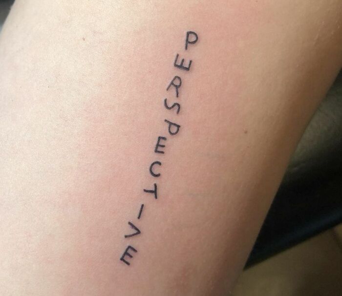 "Perspective word tattoo on skin celebrating self-love and individual importance."