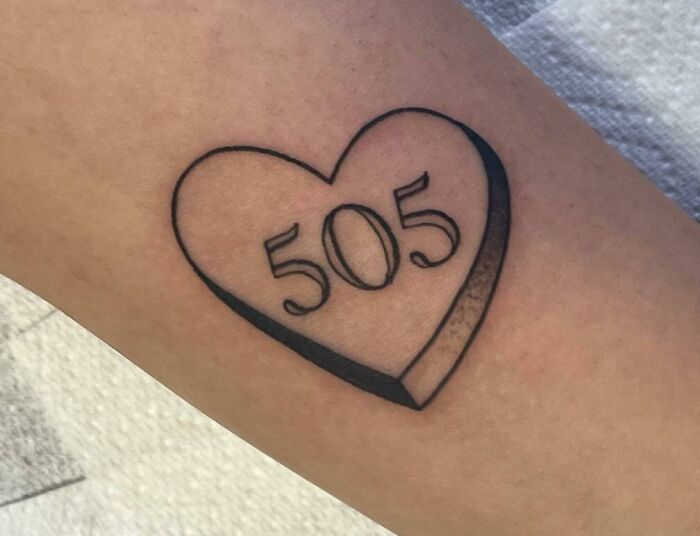 Heart-shaped tattoo with "505" inscribed, symbolizing self-love and personal empowerment.