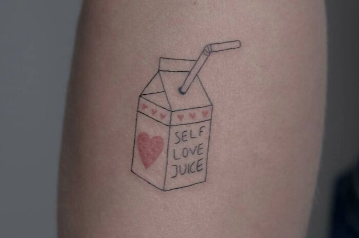 Tattoo of a juice box labeled "Self Love Juice," featuring a heart design, symbolizing self-love.