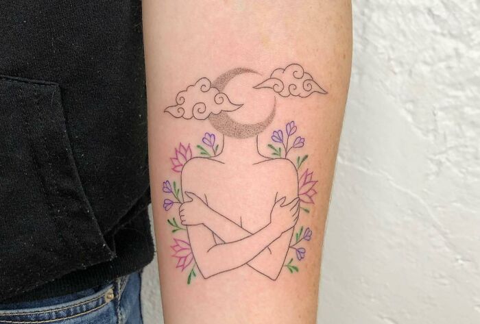 Self-love tattoo of an abstract figure hugging itself with floral and celestial elements in delicate linework.