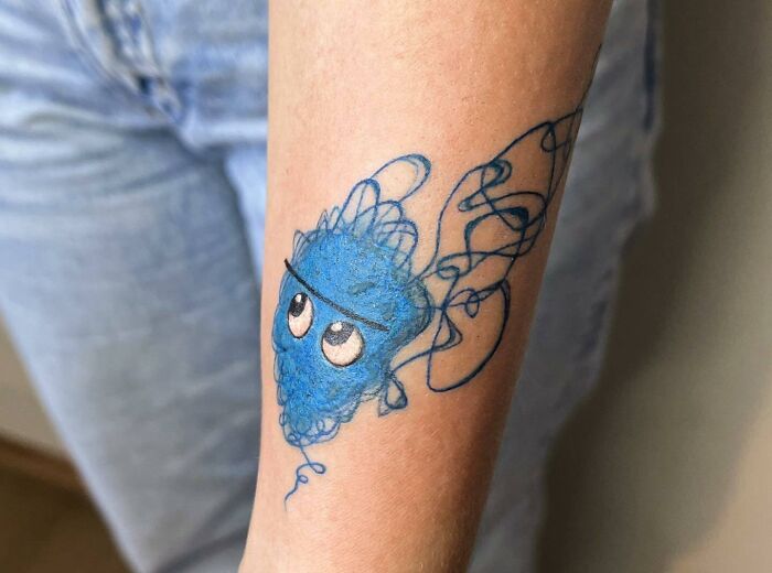 Blue anxiety blob tattoo design, symbolizing self-love on a person's arm.