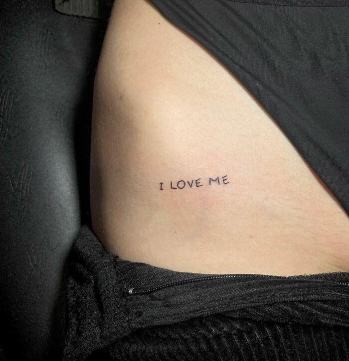 Minimalist "I Love Me" tattoo promoting self-love on the side of the body.