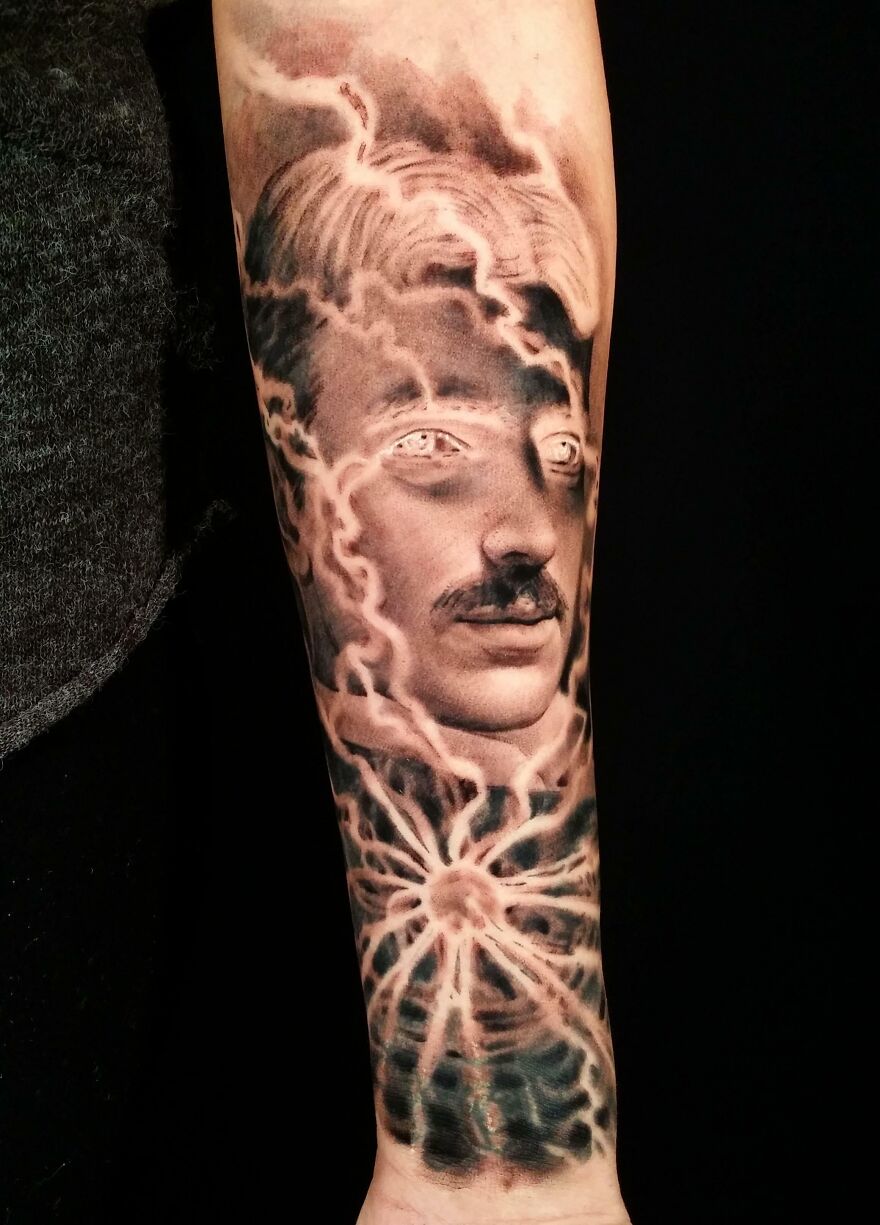 Realistic tattoo of Tesla on forearm, showcasing intricate and detailed artwork.