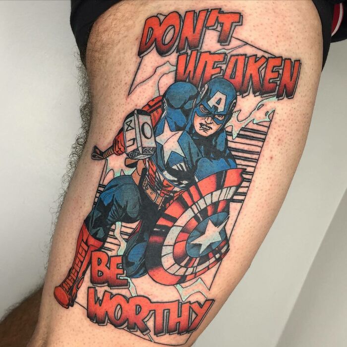 Marvel tattoo of Captain America holding Mjölnir with "Don't Weaken Be Worthy" text on a person's leg.