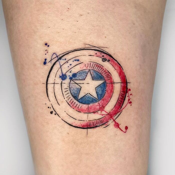 Watercolor Captain America shield tattoo, showcasing Marvel superhero art.