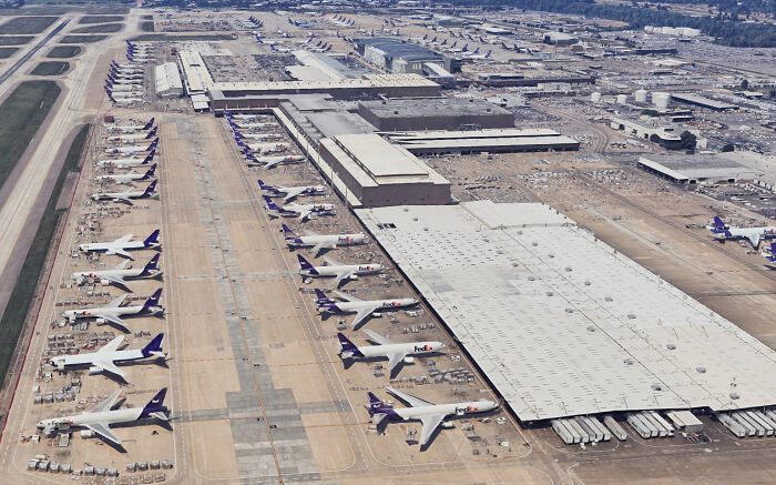 Aerial view of an organized airport with multiple FedEx planes parked, showcasing efficient and well-planned infrastructure.