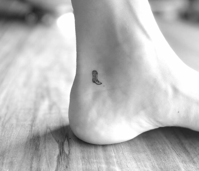 Minimalist tattoo of a cowboy boot on the ankle, inspired by celebrity tattoos.