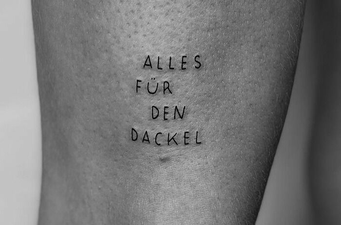 Word tattoo in German on skin, saying "Alles für den Dackel."