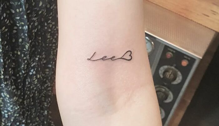 Minimalist word tattoo with a heart, ideal for new ink ideas.