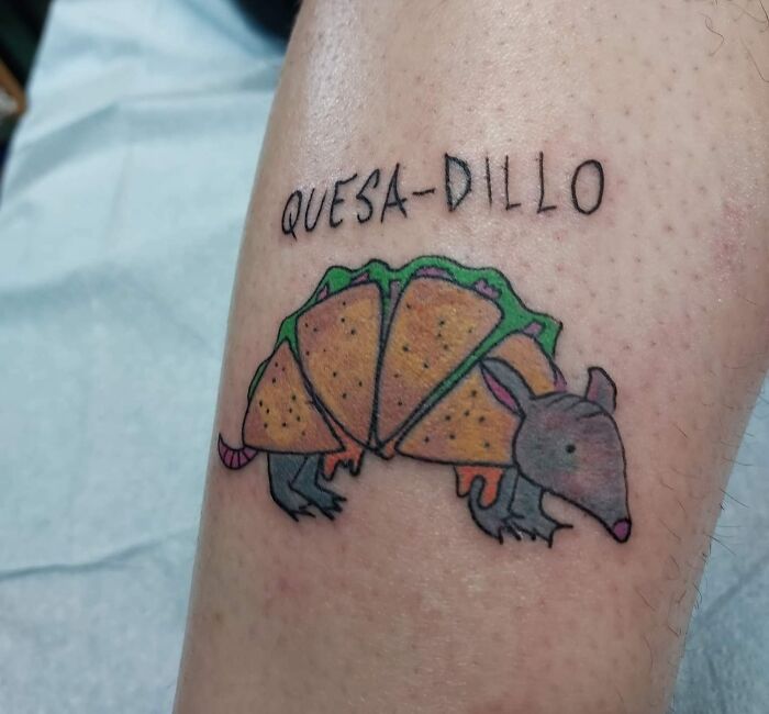A whimsical armadillo tattoo with taco shell armor, captioned "Quesa-Dillo." Perfect for unique word tattoo ideas.