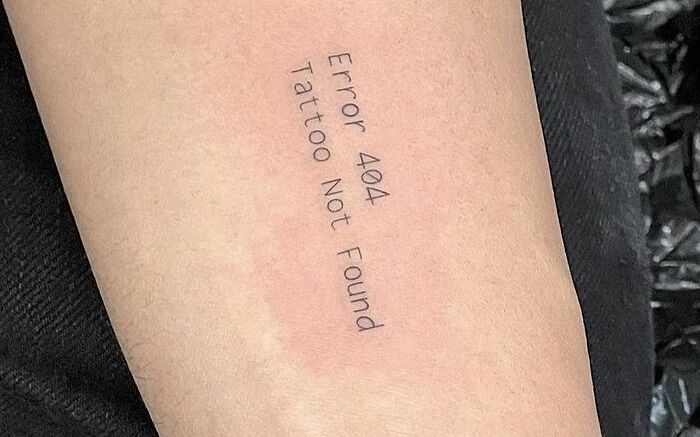 "Error 404 Tattoo Not Found humorous word tattoo on arm."