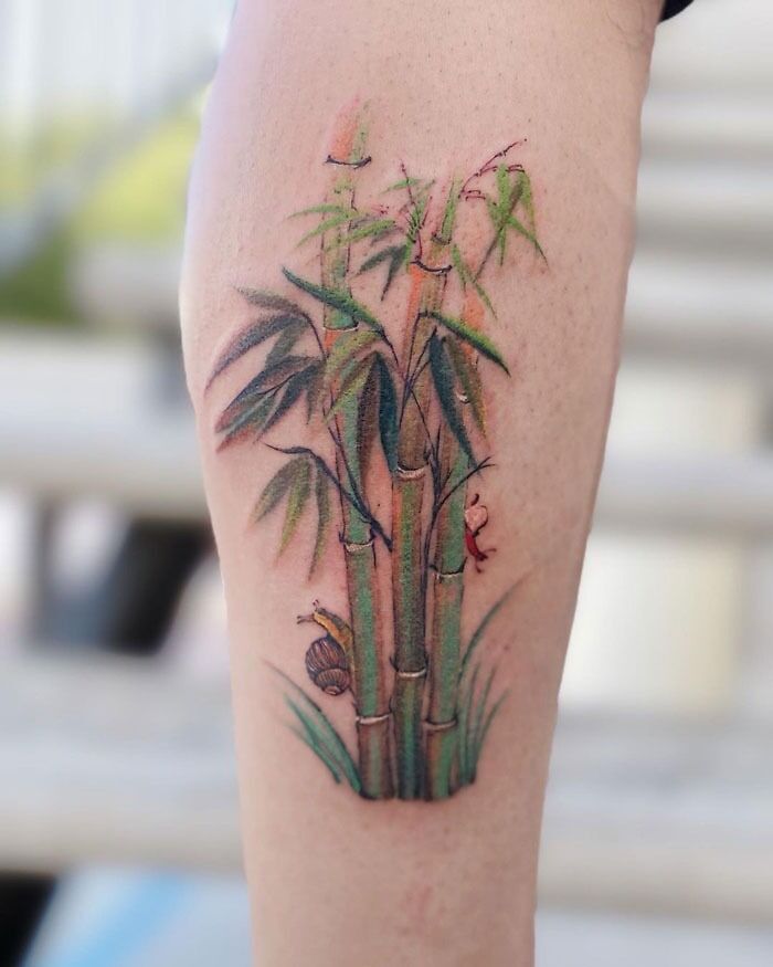 Unique calf tattoo featuring bamboo with vibrant leaves and detailed insects.