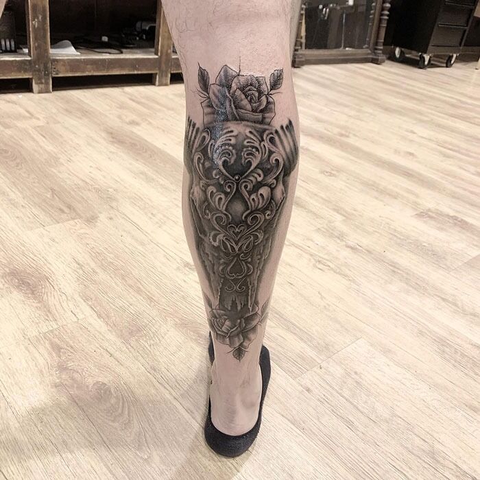 Intricate calf tattoo design featuring detailed patterns and floral elements, showcasing unique tattoo art on leg.