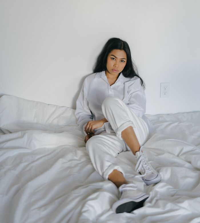 Woman Lying In Bed With Shoes 
