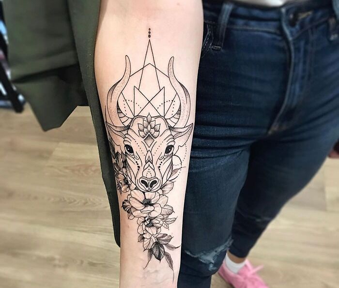 Bull tattoo on forearm with geometric and floral design, showcasing animal kingdom admiration.