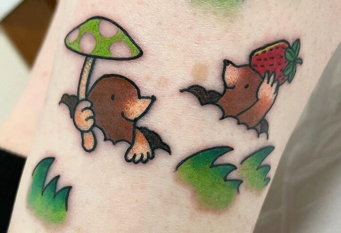 Cute animal tattoos of moles holding a mushroom and strawberry, celebrating the animal kingdom.